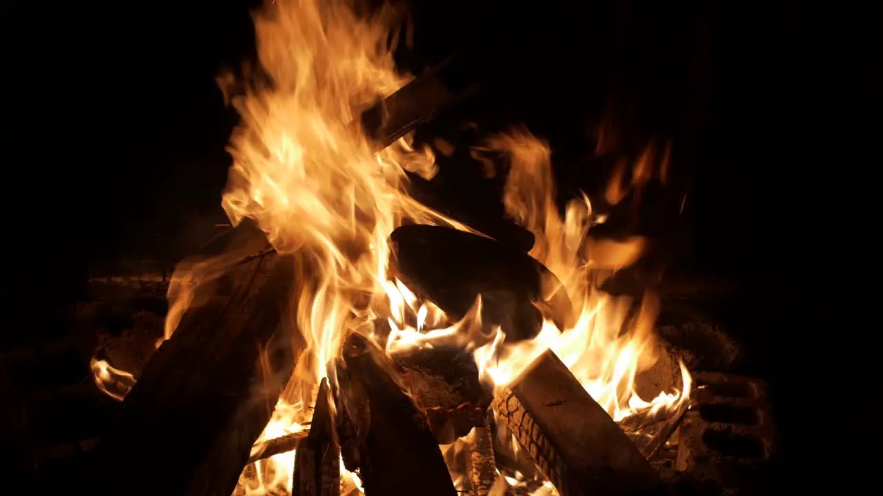 Wood fire burning intensely with flames dancing wildly filmed as medium close up shot