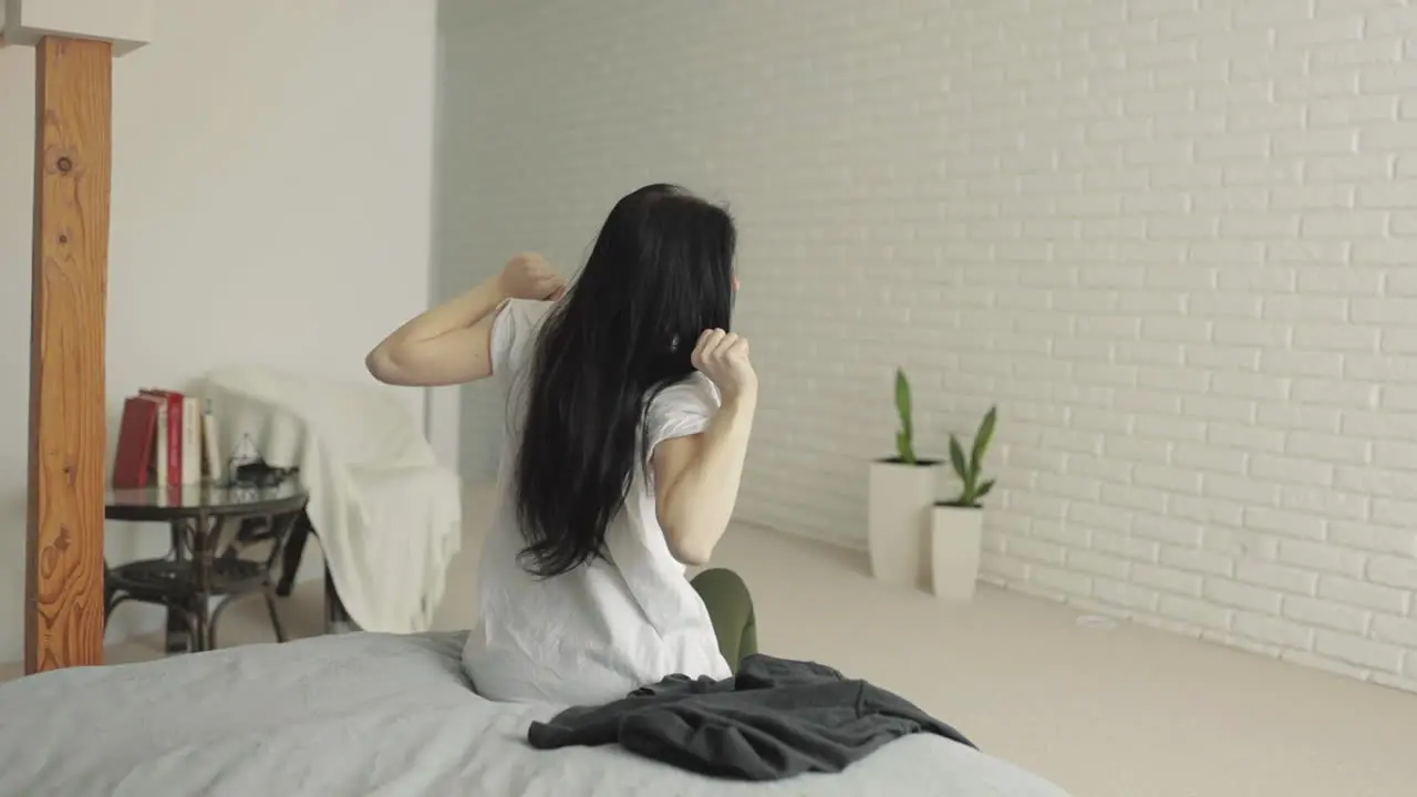 Young Woman Waking Up Stretching Getting Dressed And Getting Out Of Bed At Home