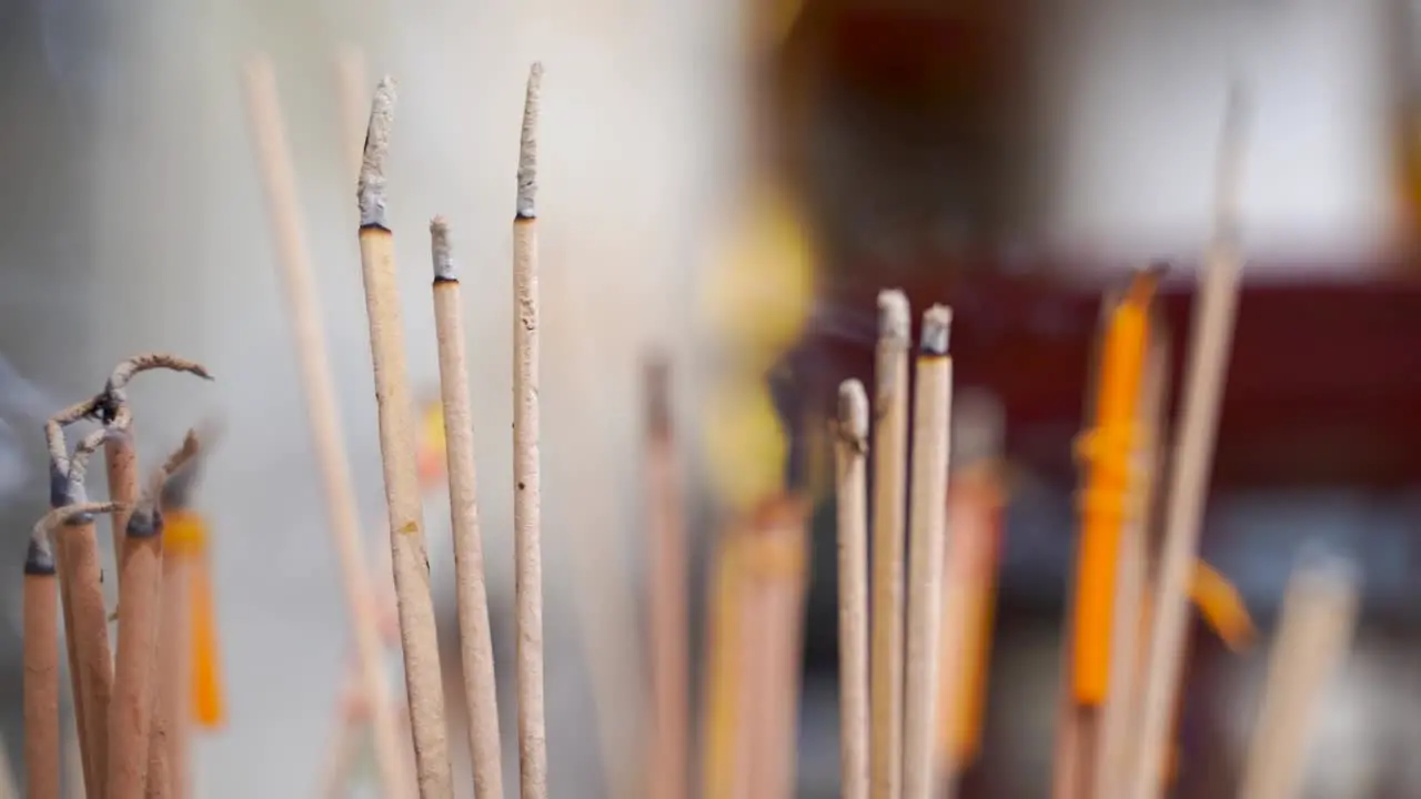 Handheld close up view of Incense burning with background blur