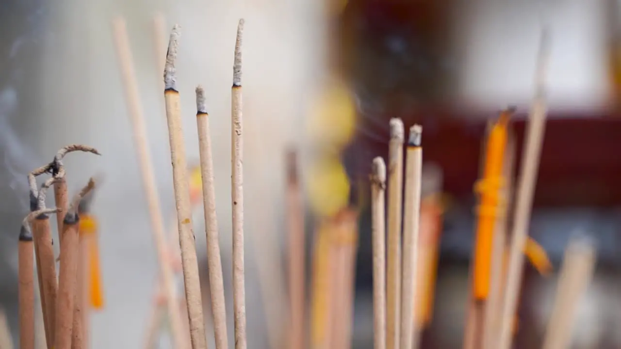 Handheld close up view of Incense burning with background blur in slow motion