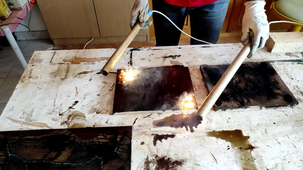 Close up of wood burning with high voltage electricity and flames to create river holes in the wood