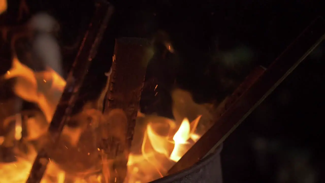 Kindling openly burns in a metal barrel