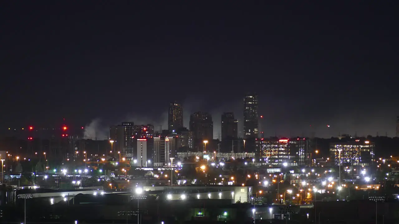 Time lapse of beautiful night cityscape with burning fire smoke at the background