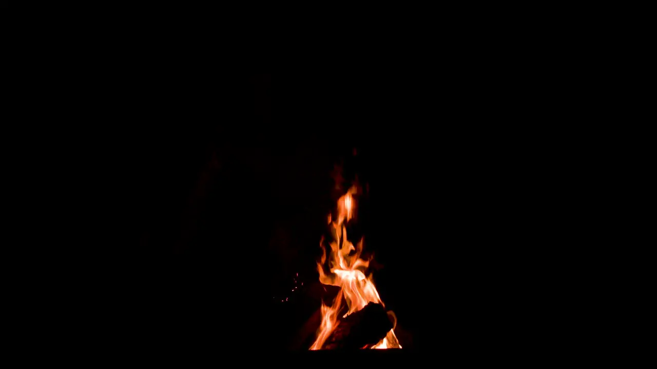 Sparks flying out of a camp fire wide shot 4k slow motion 100fps