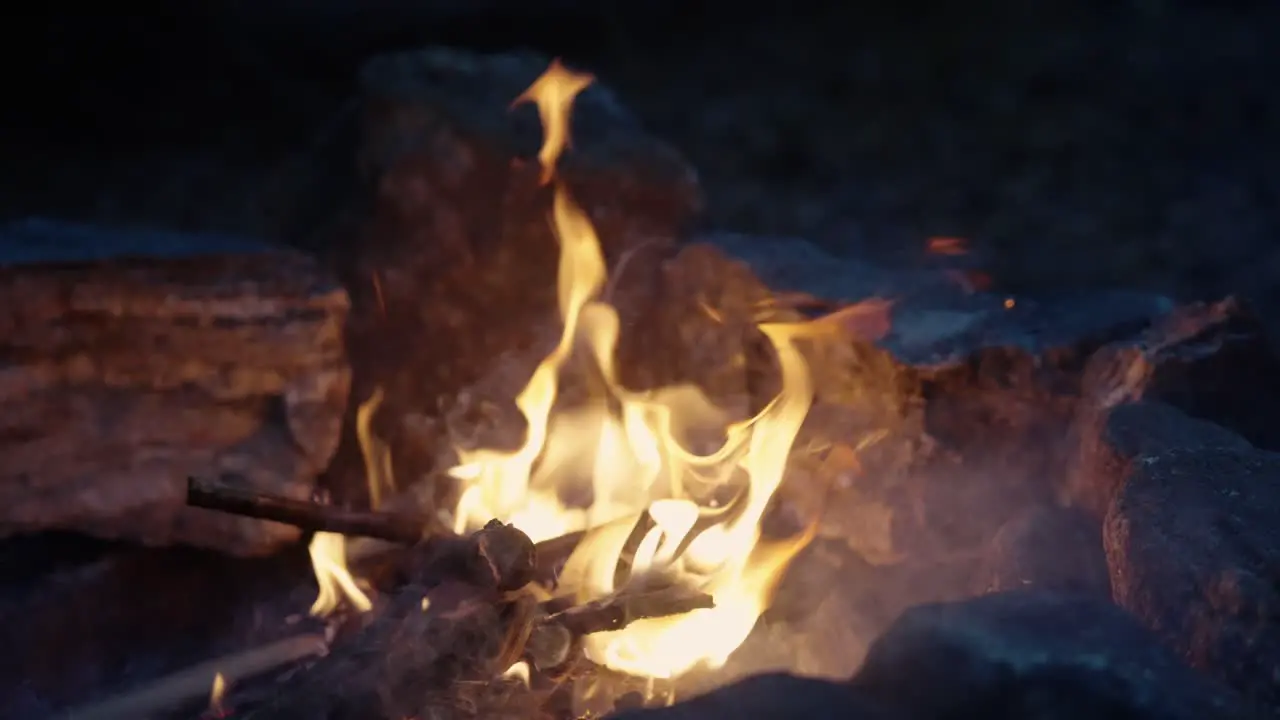 Bonfire burning bright in Slow Motion peaceful orange campfire with sparks surrounded by stones Close-up 4k