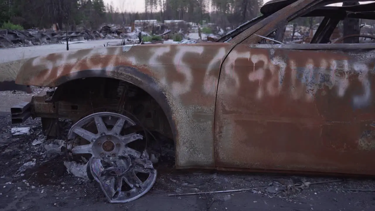 Slider shot across side of burned car in Paradise California wildfire aftermath