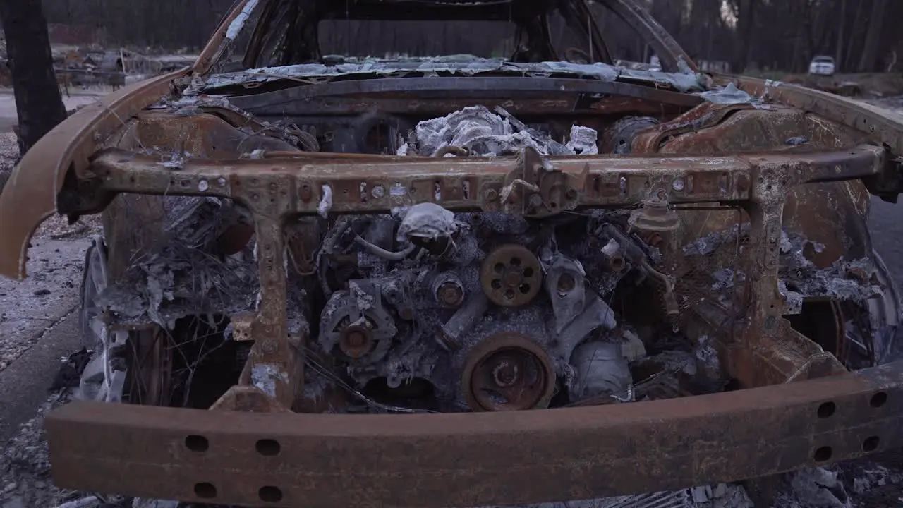 Slider shot across front of burned car in Paradise California wildfire aftermath