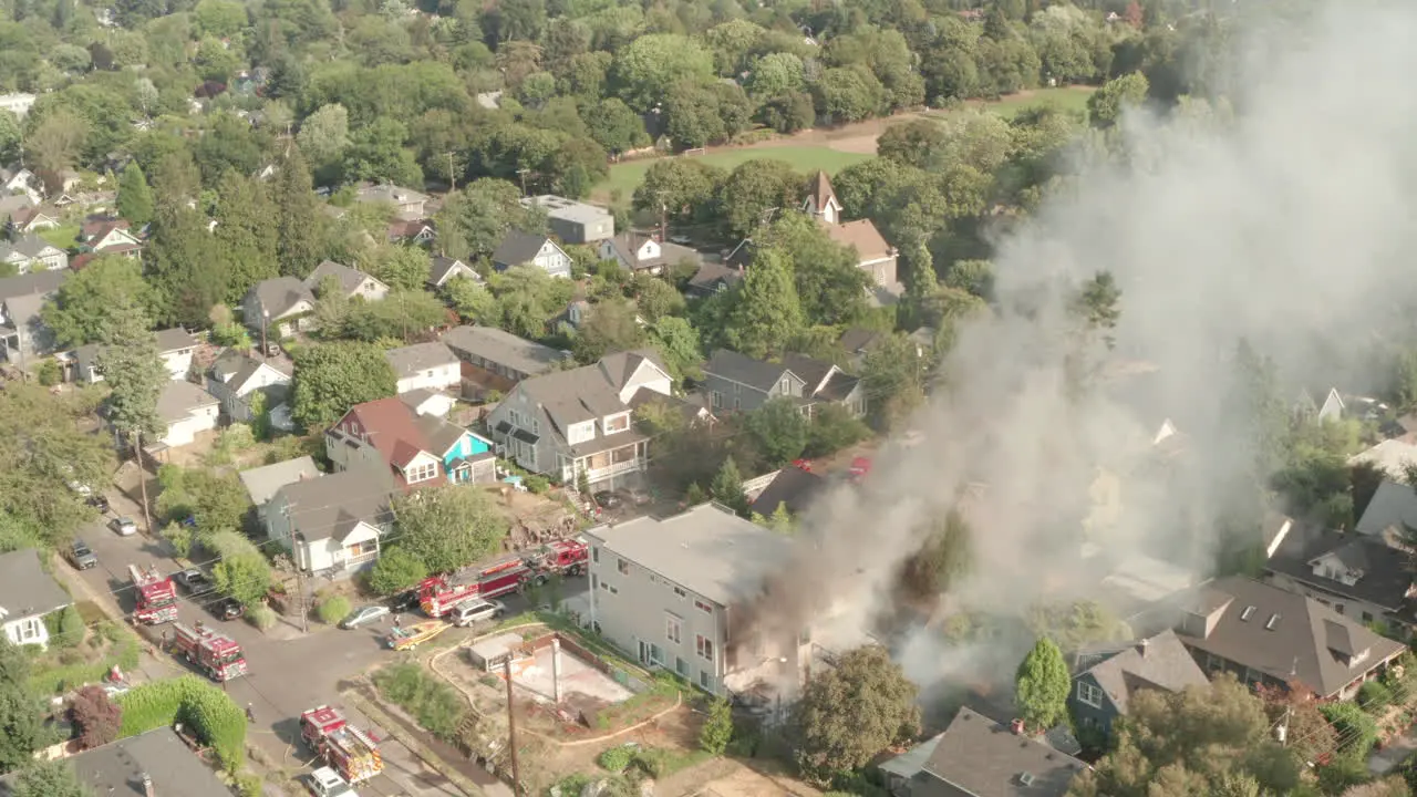 Aerial shot towards Fire engines surrounding a burning building