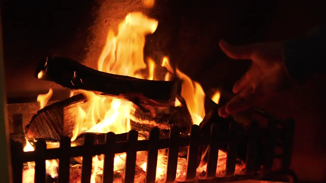 Throwing a log on the fire in slow-motion in a home fireplace