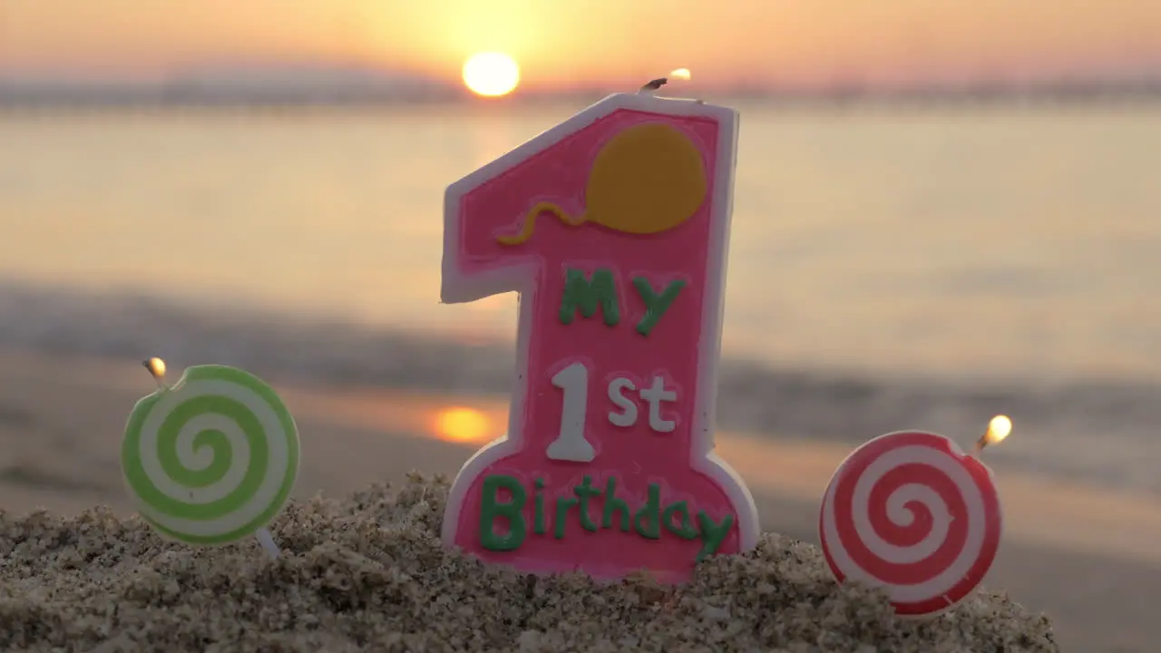 One year old birthday candle on the beach