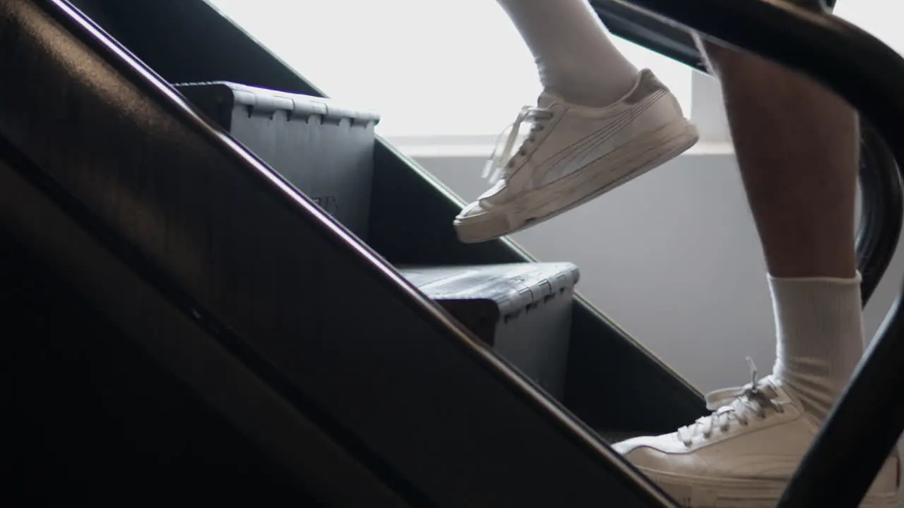 Close-up of Man feet Walking Up on Stepmill Climbing Stair Treadmill Machine in Sport Club