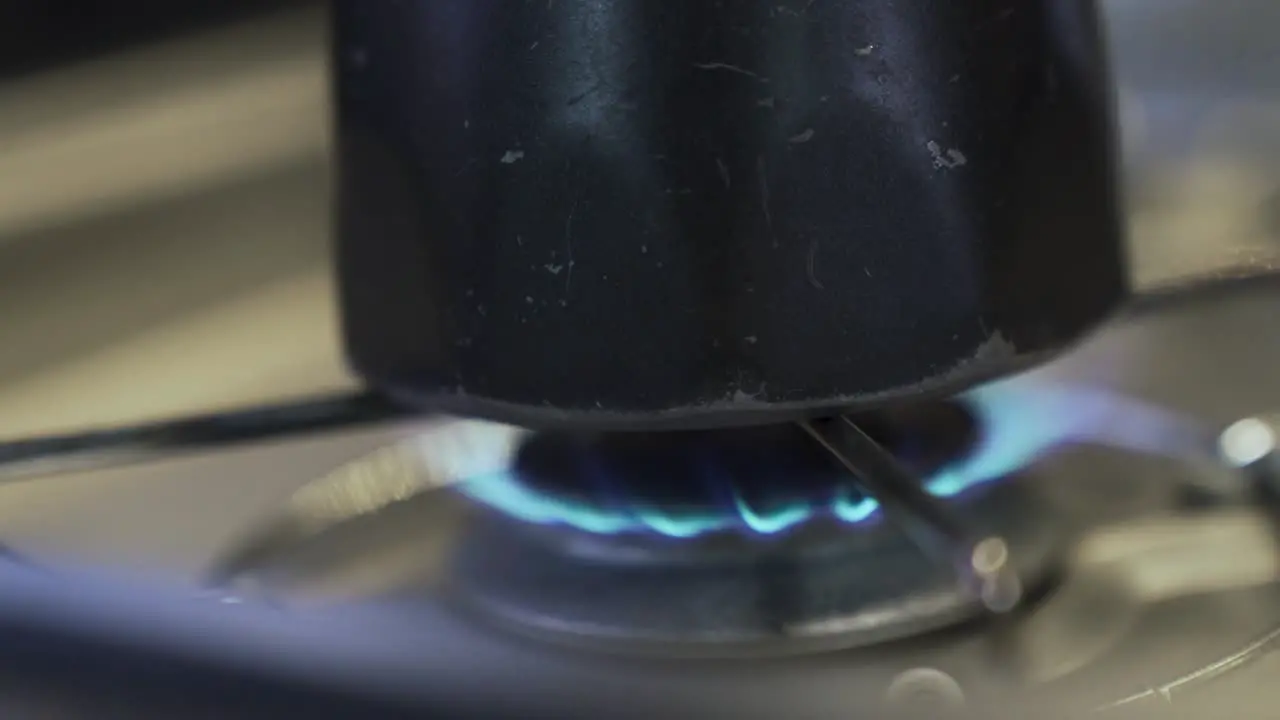 turning on a gas burner and putting a kettle on it