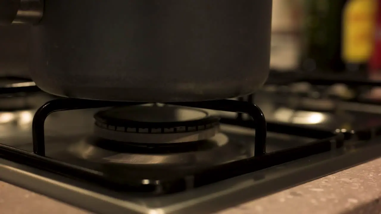 Turning gas stove off with pot on top close up slow motion