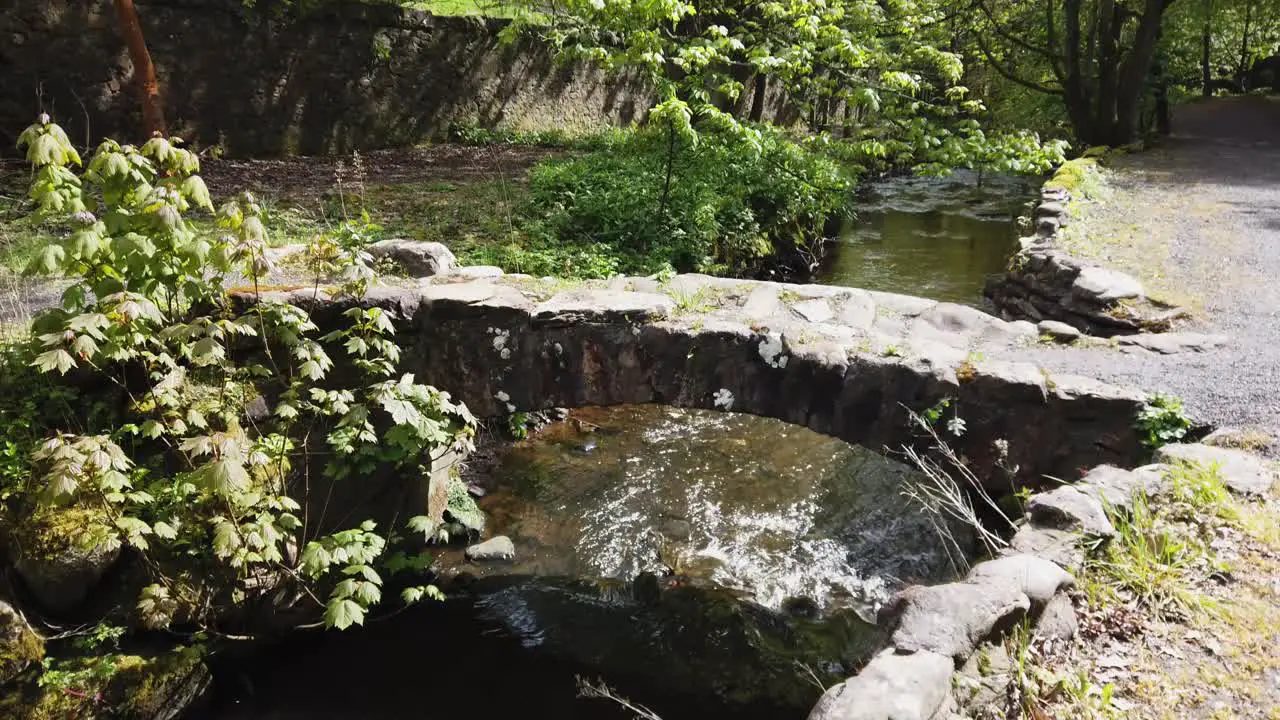 Ancient bridge in a small glen in Fife Scotland with a small burn flowing through it