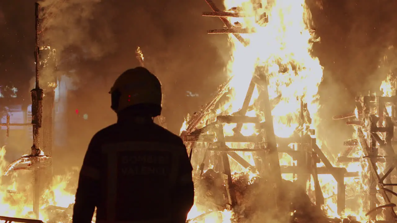 Fireman controls the bonfire of Las Fallas festival in Spain