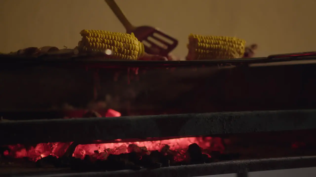 Roasting meat and corn on charcoal grill