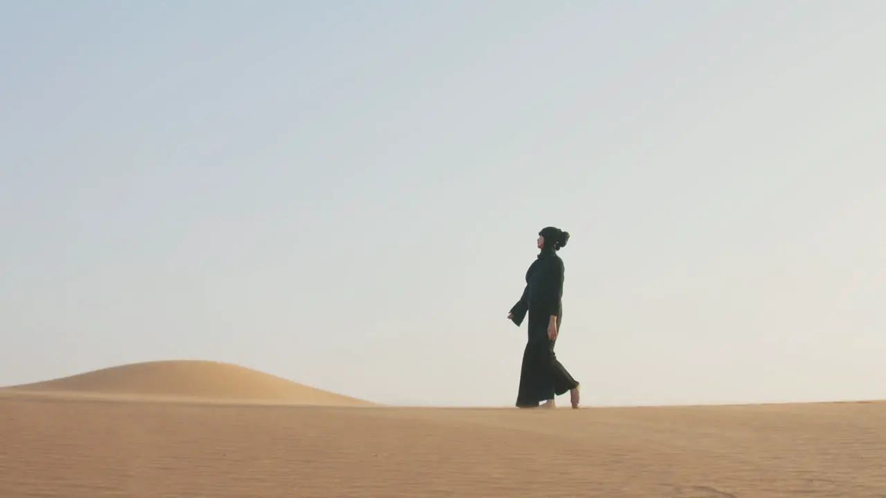 Muslim Woman In Hijab Walking Barefoot In The Desert