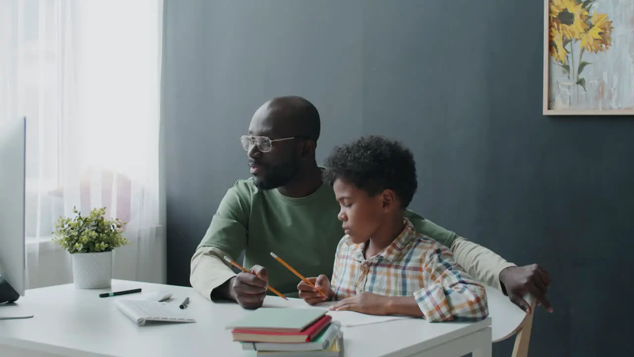 African American Father Helping Son with Taking Online Lesson at Home