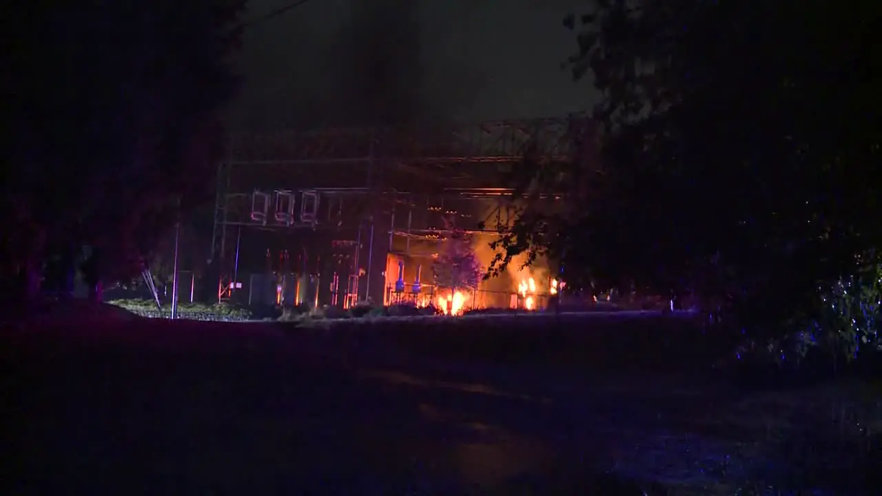 WIDE SHOT OF TRANSFORMER SUBSTATION ON FIRE AT NIGHT