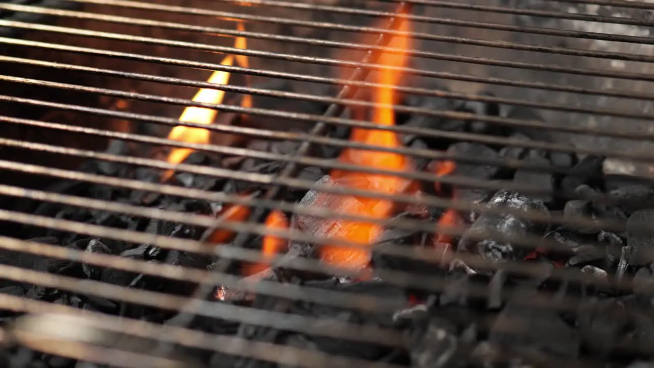 empty charcoal grill with grate and burning fire