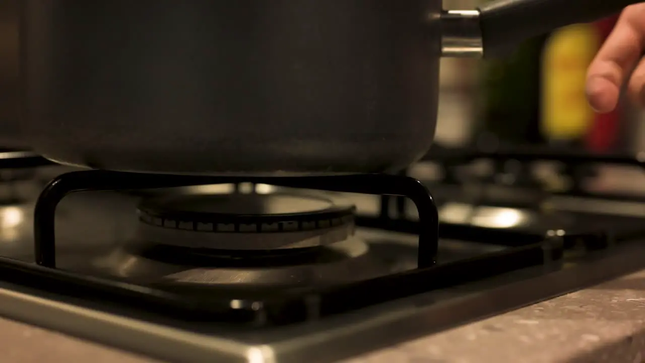 Turning gas stove off and removing pot close up slow motion