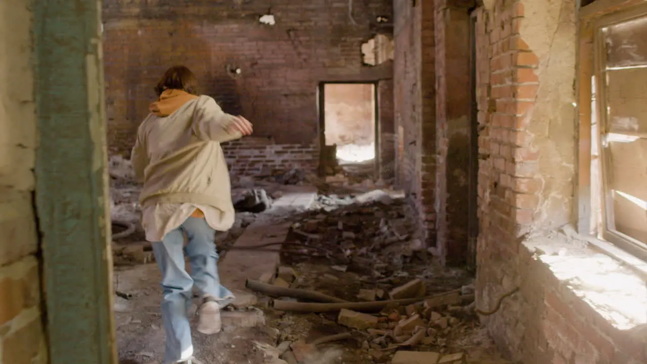 Rear View Of A Redhead Girl Running Away In A Ruined Building