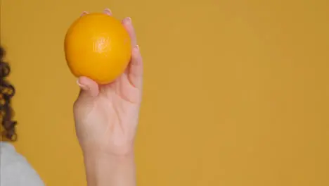 Close Up Shot of Young Adult Woman Holding Orange