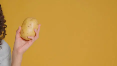 Close Up Shot of Young Adult Woman Holding Potato