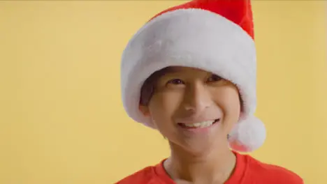 Smiling Young Boy in Santa Hat Jumping 