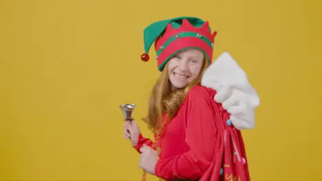 Close Up Young Girl Holding Christmas Sack and Bell with Copy Space