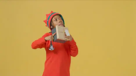 Smiling Boy Ringing Bell and Holding Christmas Present