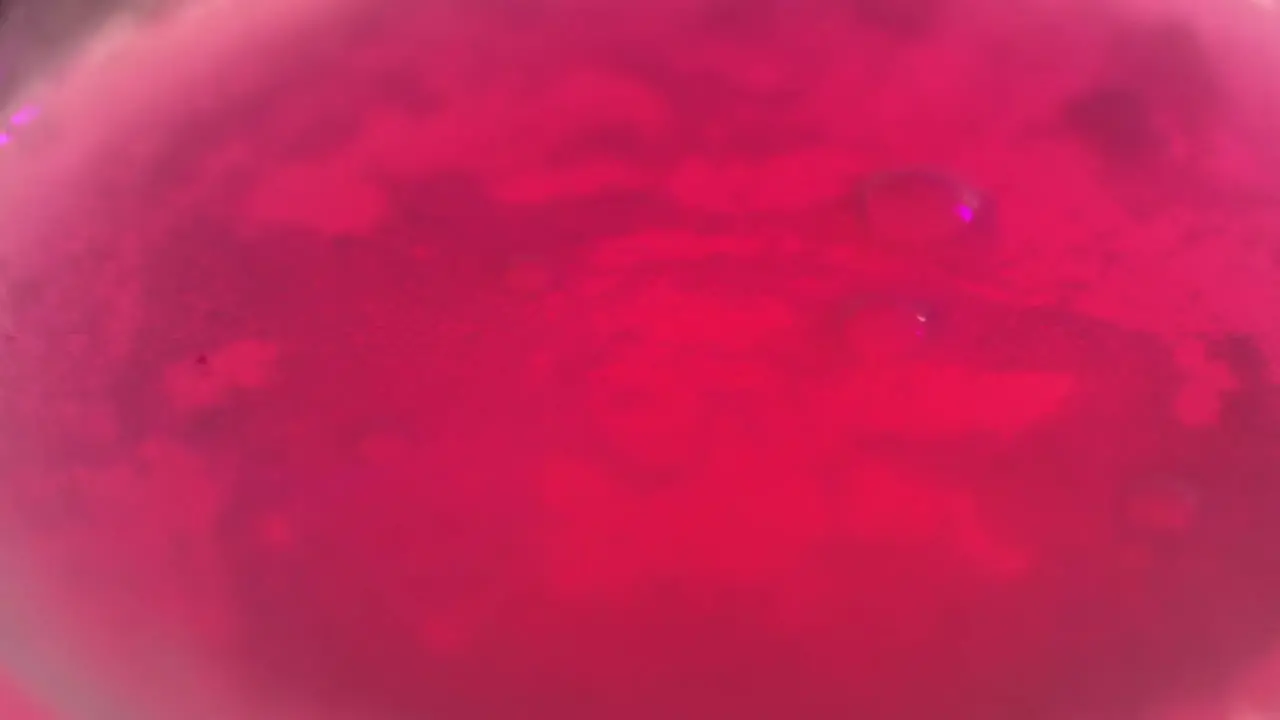 vibrant pink bubbles pop from carbonated Japanese bath salts in slow motion