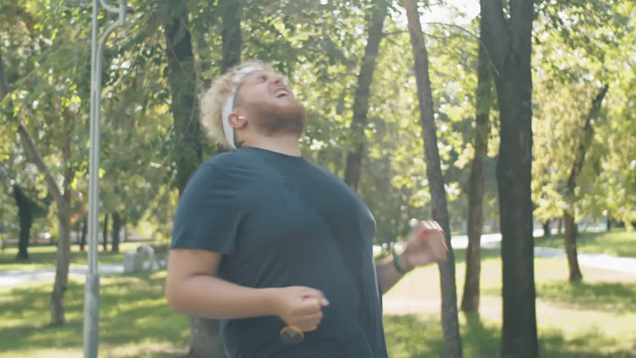 Obese Man Celebrating Running Goal Achievement while Training in Park