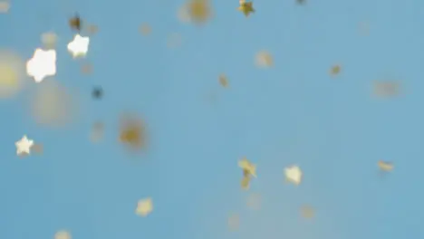 Stationary Shot of Gold Confetti Falling Against a Blue Background