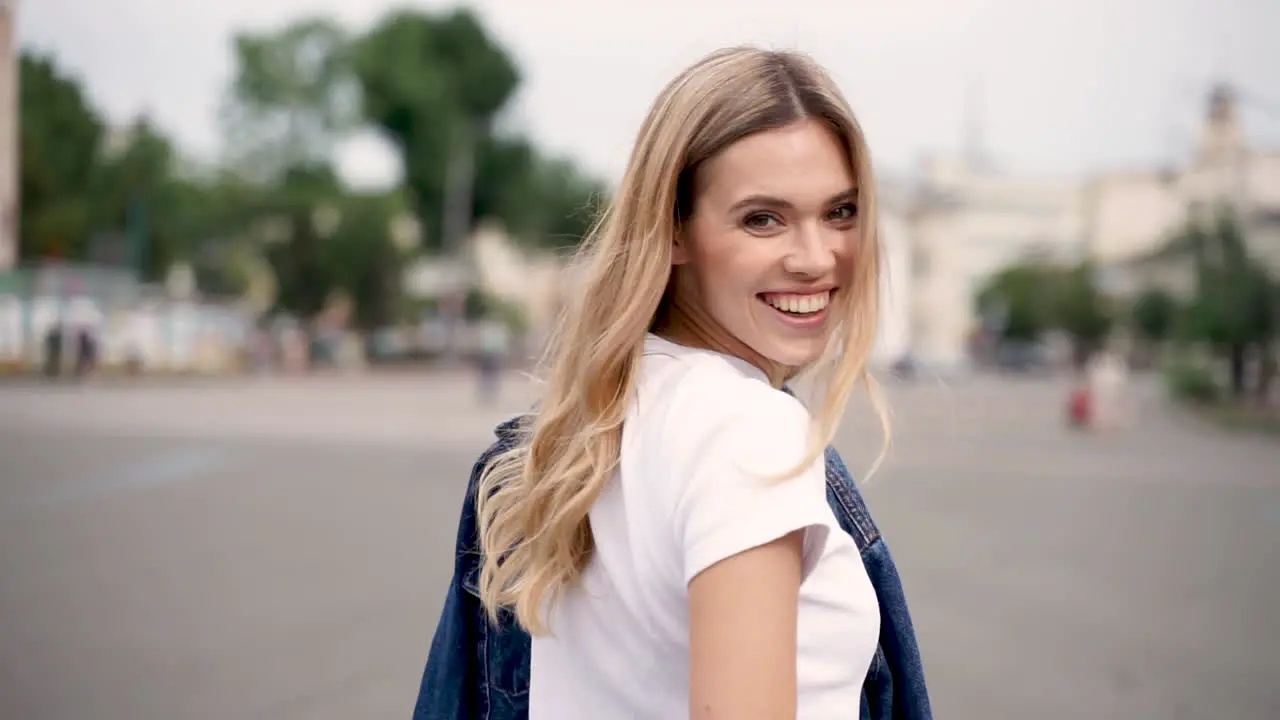 Happy Young Woman Smiling Looking Back And Walking Down The Street