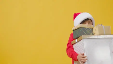 Mid Shot of Boy Walking Holding Christmas Presents