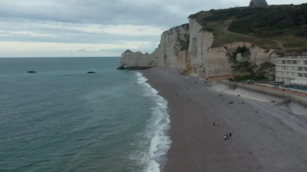 Etretat cliffs on Stormy Cloudy Day with people on the beach and Ocean View