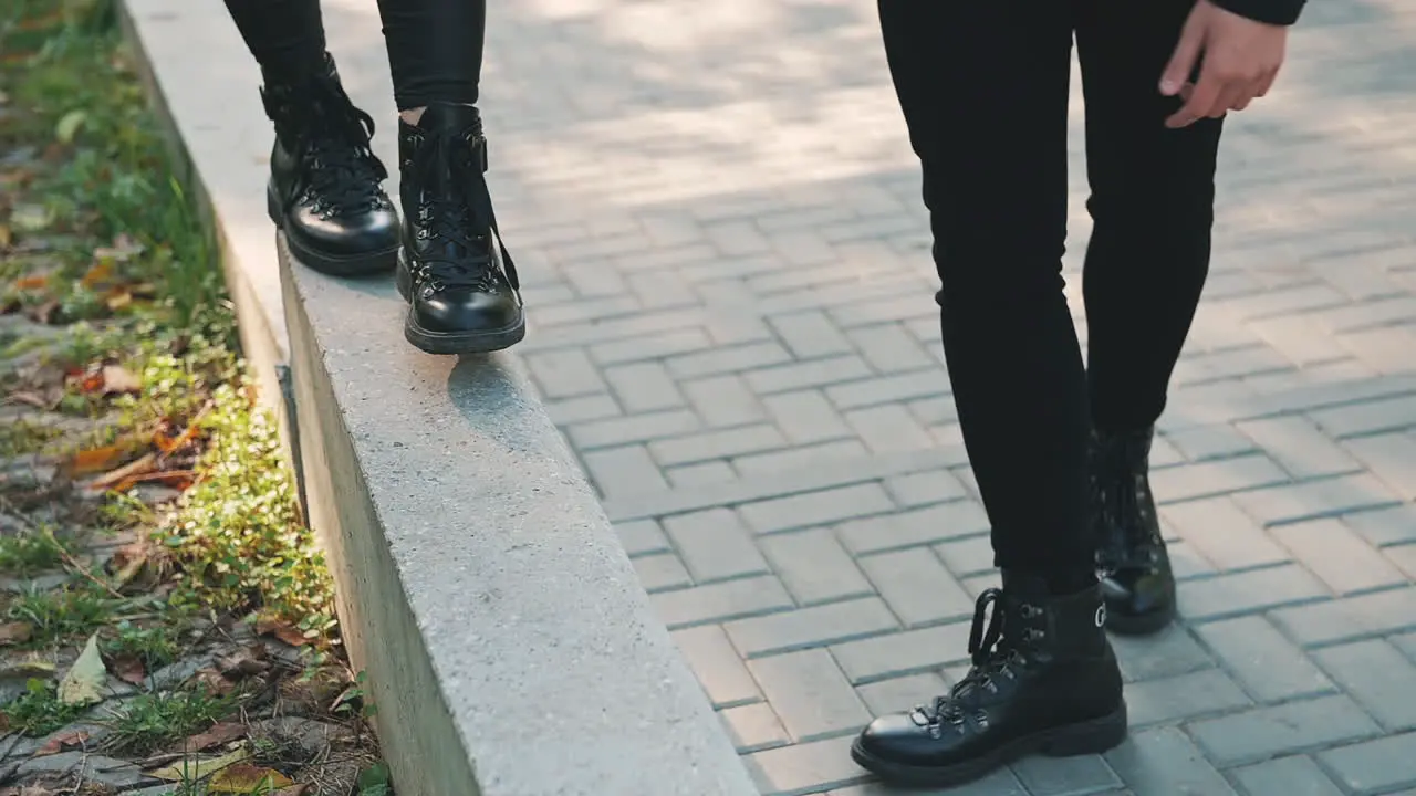 Woman's Boots Walking On A Curb 1