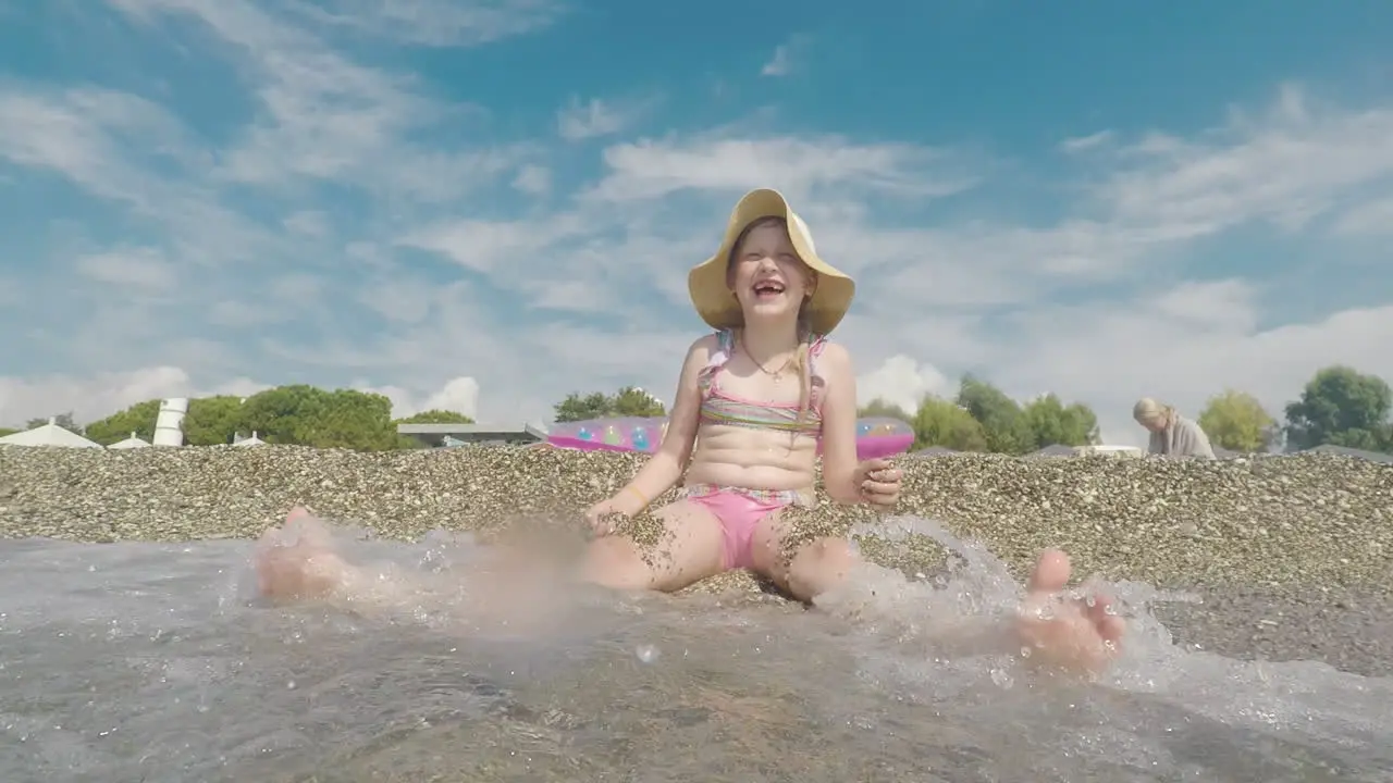 A Cool Girl In A Pink Bathing Suit And Wearing A Broad-Brimmed Hat Is Having Fun On The Seaside Play