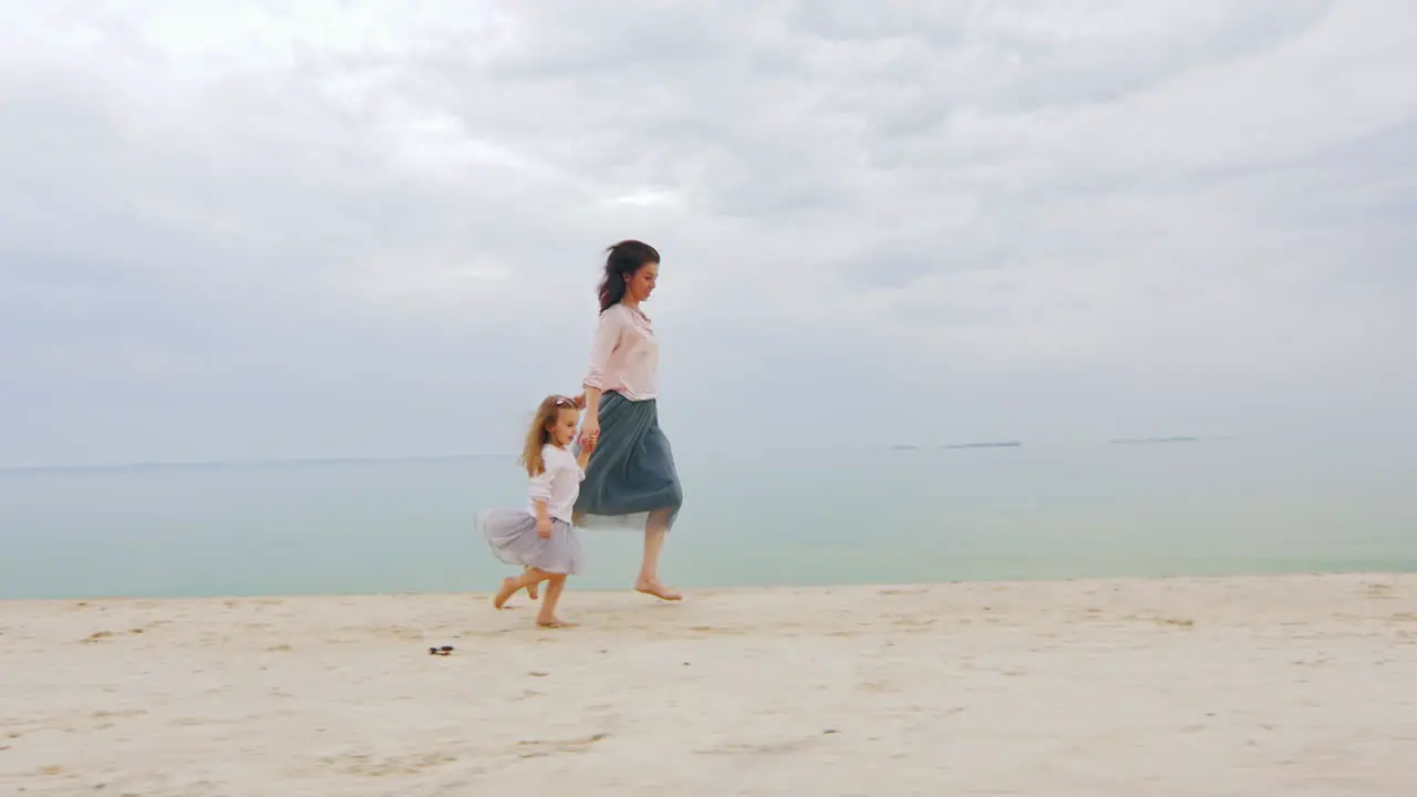 Mom And Daughter Having Fun Running Around On The Beach Happy Childhood