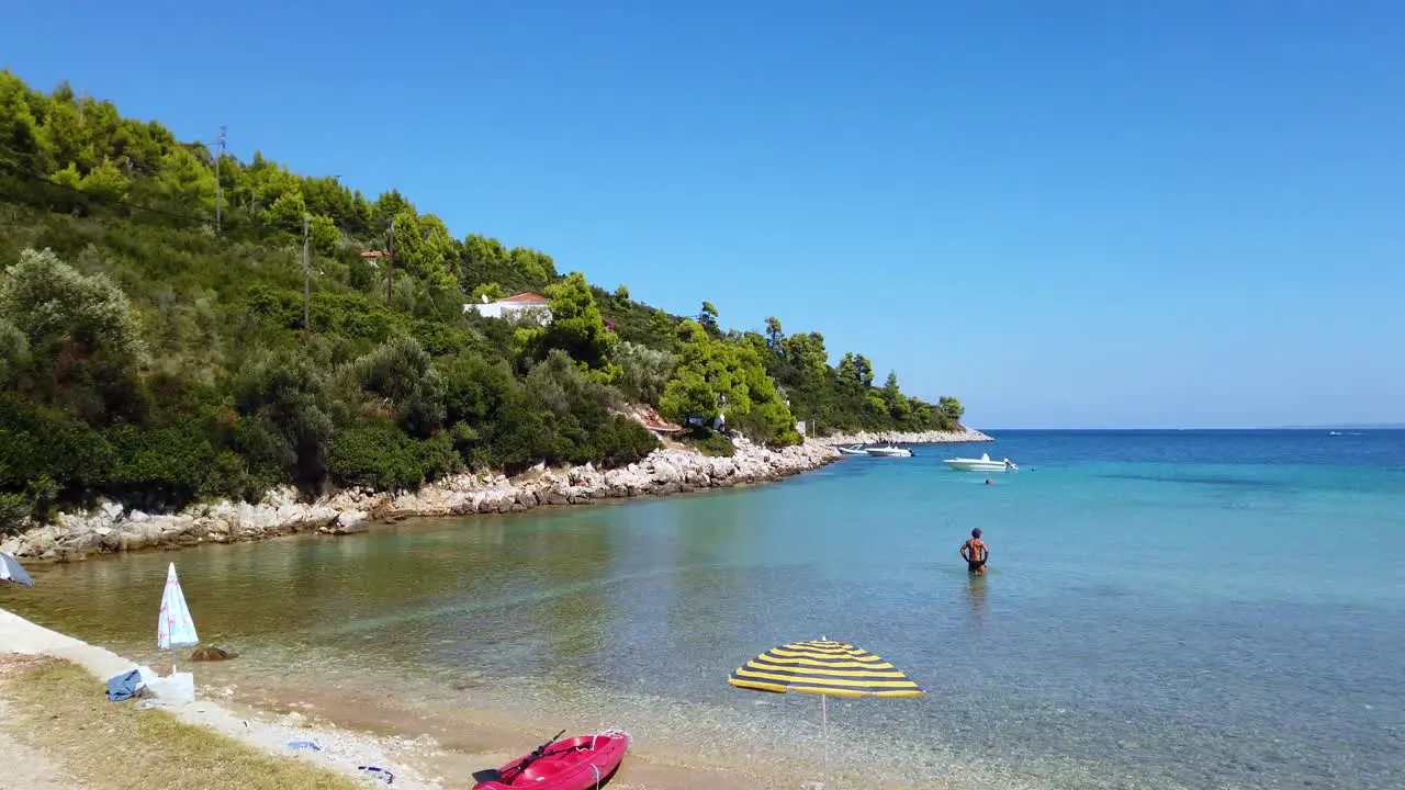 Panning Shot Of A Stunning Beach And An Individual walking In The Sea At Naxos Greece