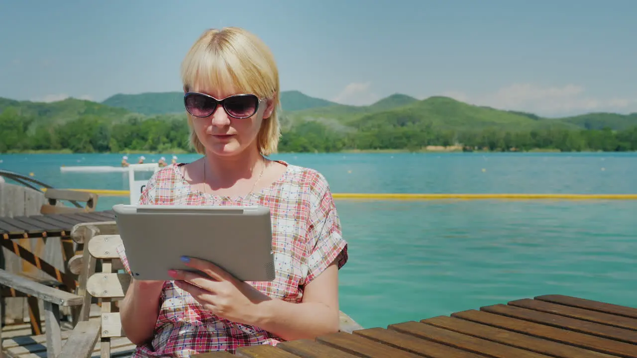 Young Woman With The Tablet Sitting In A Cafe On The Terrace On The Background Of The Picturesque La