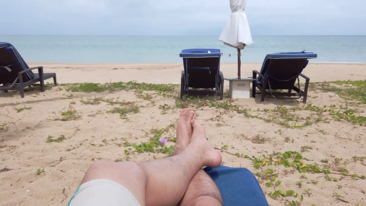 POV of man walking with barefoot on white sand beach in slow-motion in summer holiday vacation