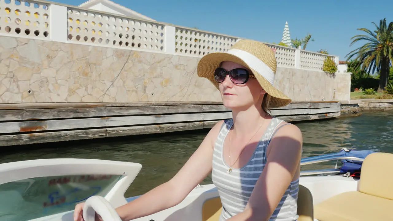 Young Woman Enjoying A Holiday Resort In Europe Floating On A Boat On The Channel Empuriabrava Spain