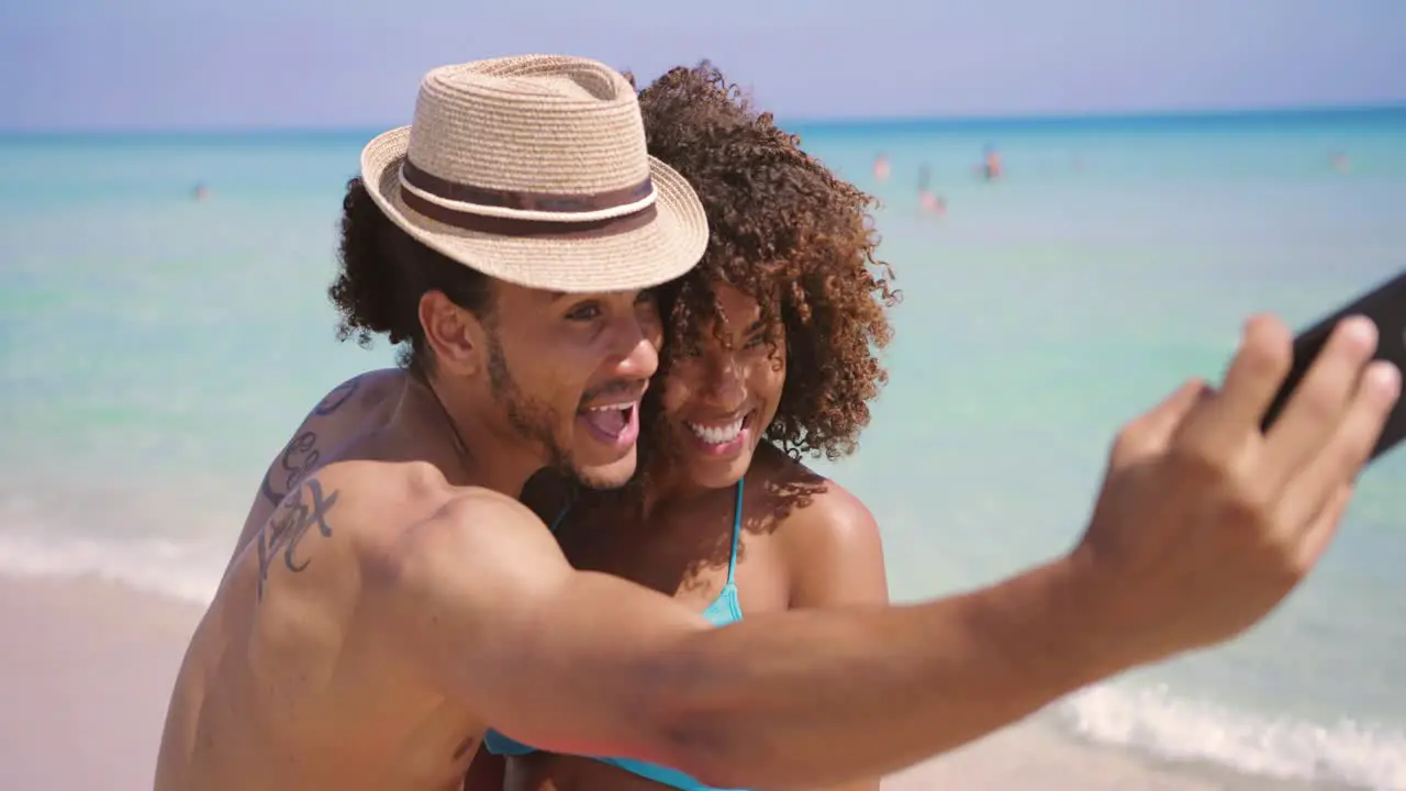 Cheerful happy couple selfies on beach