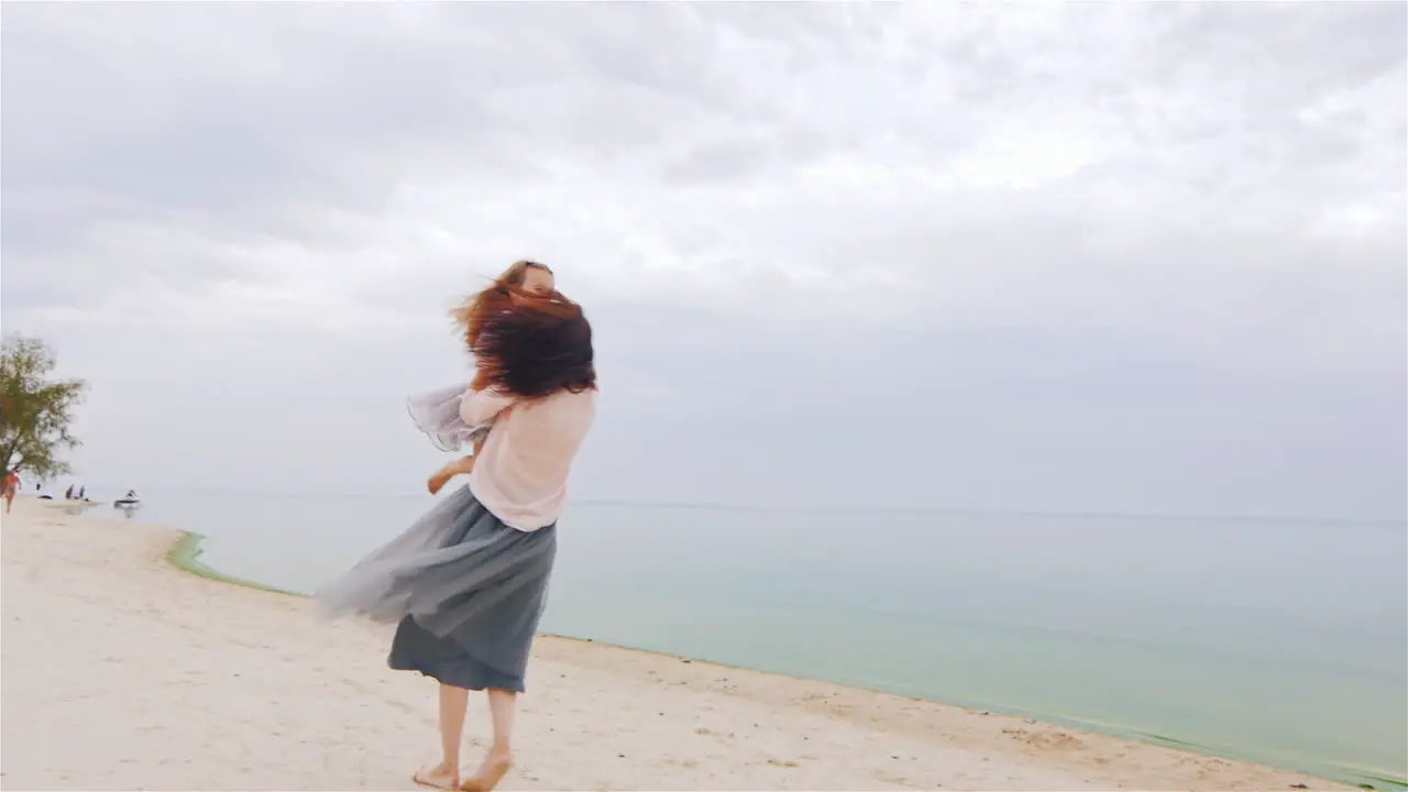 Cheerful And Carefree Mother Playing With Her Daughter On The Beach