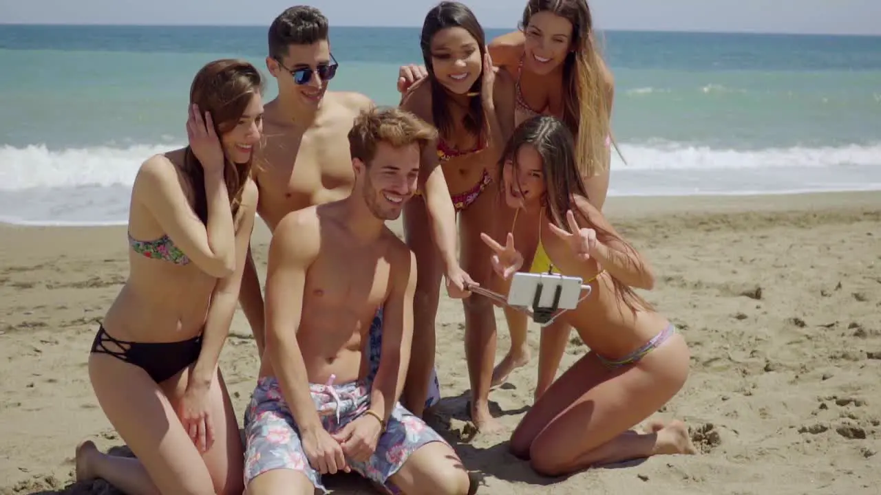 Group of Friends with Metal Detector on Beach