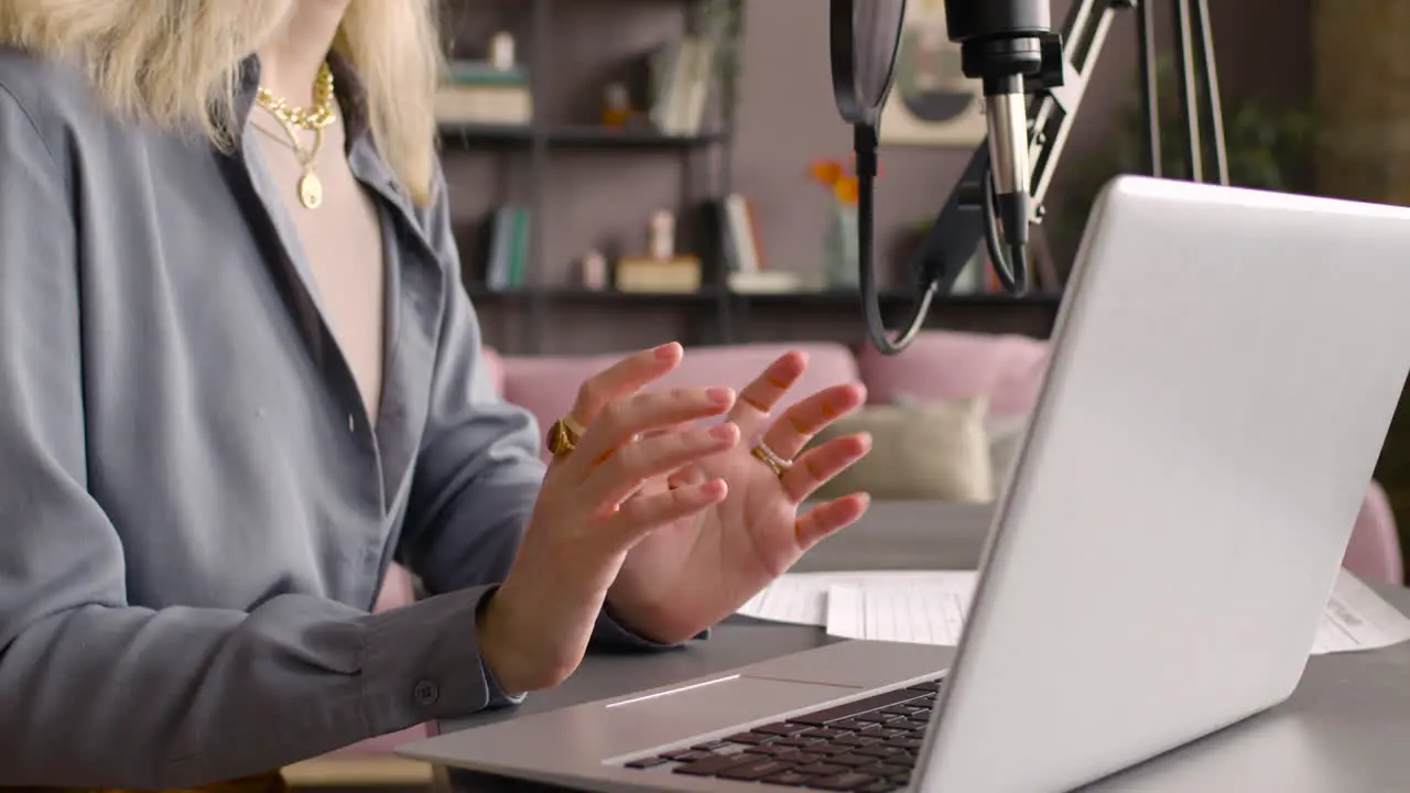 Camera Focuses Woman Hands Gesticulating While Recording A Podcast Sitting At Desk With Laptop