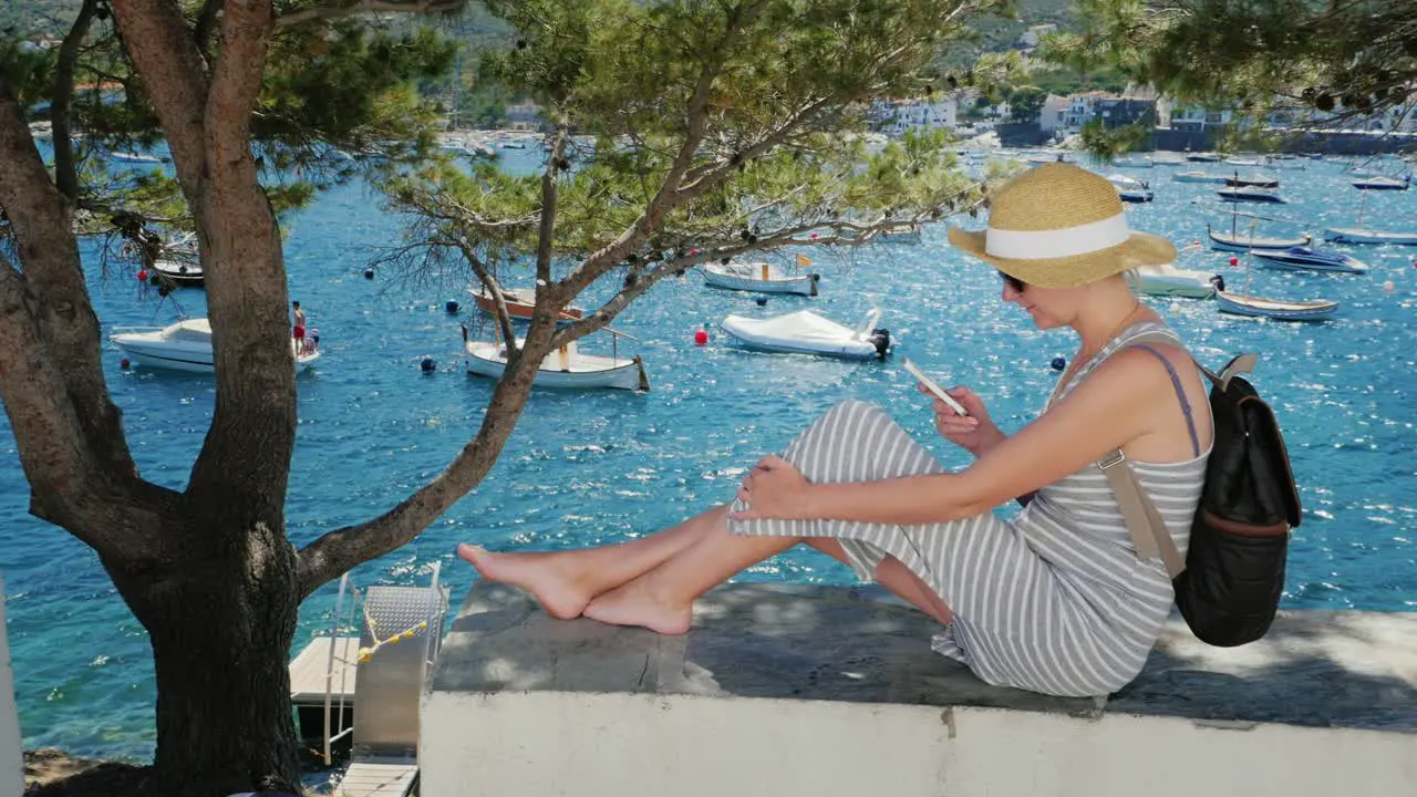 A tourist uses a smartphone and sits in the shade