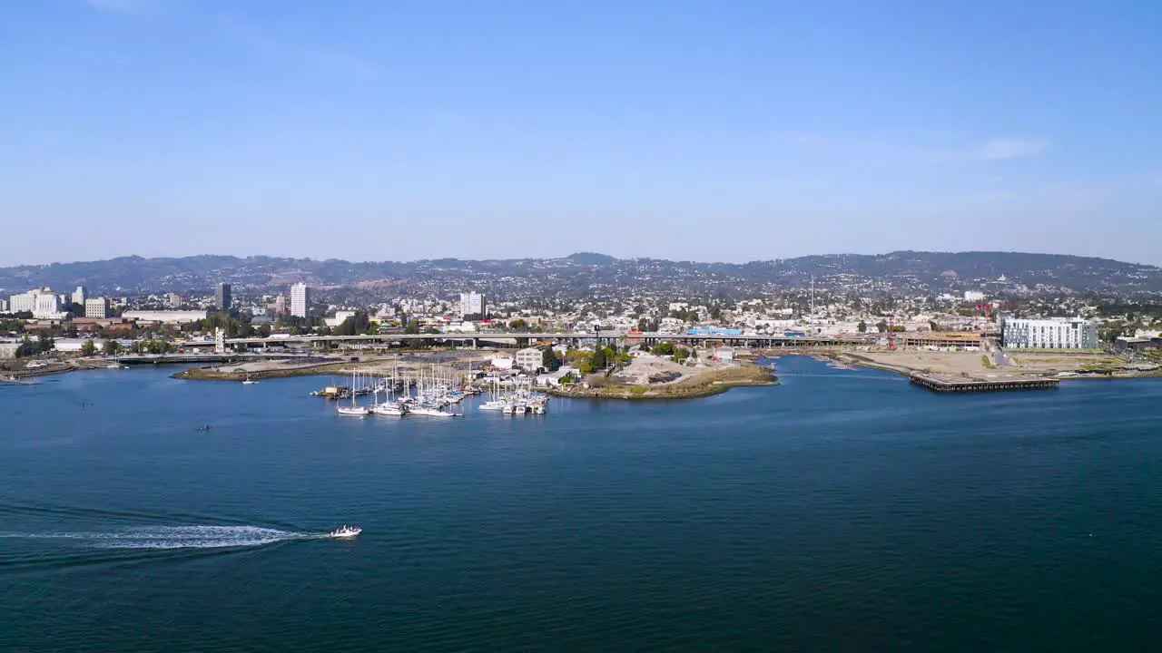 Boats on a lazy day in the bay pass the shore and the wonderful city